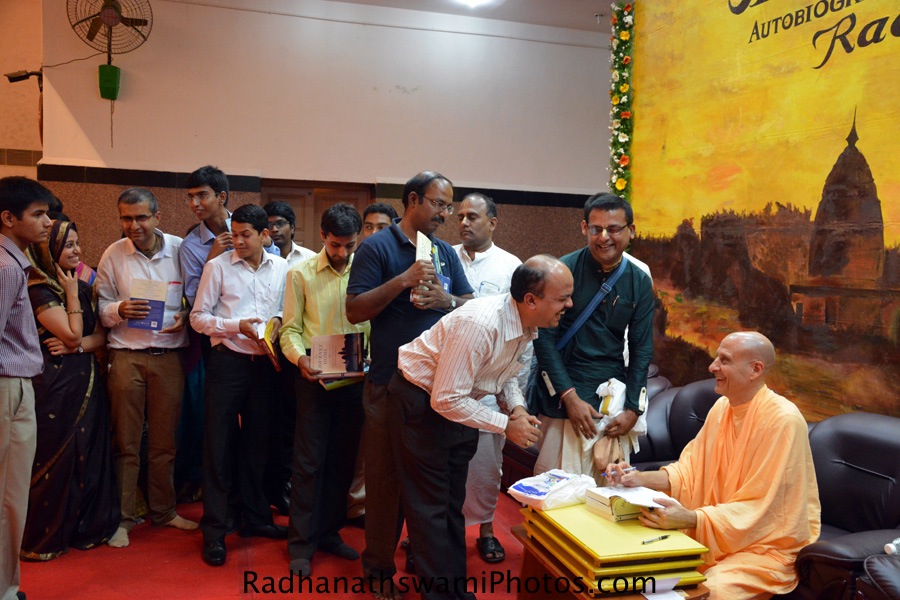 Radhanath Swami signing the book during chennai book launch